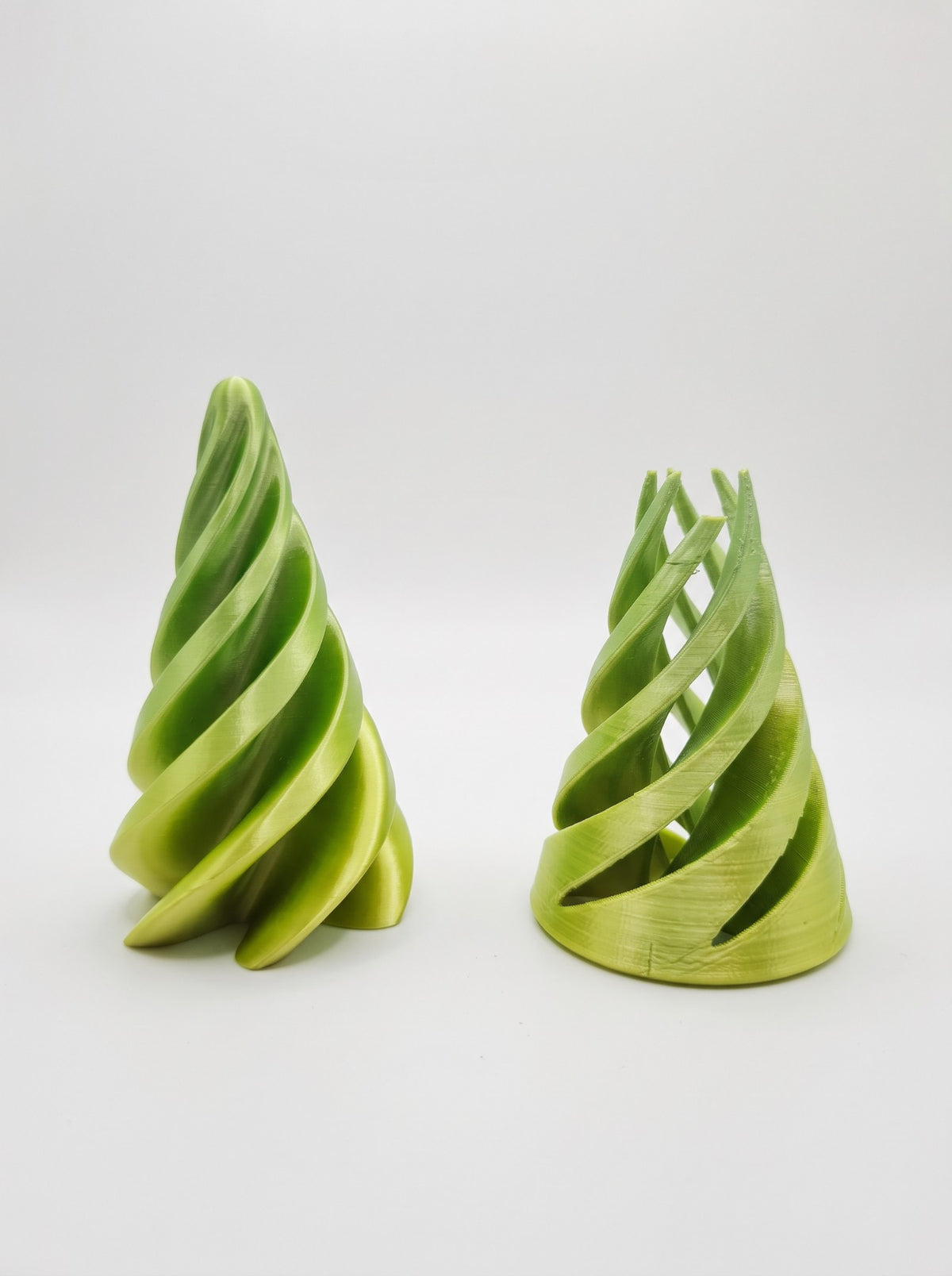 Conos espiral 3D verdes, uno de pie y otro con las láminas abiertas