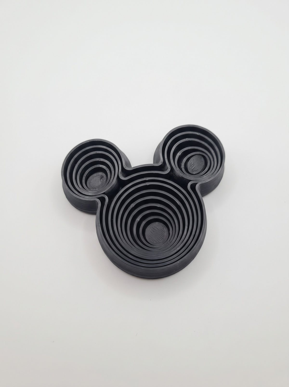 Fidget de anillos concéntricos negro con forma de cabeza de ratón