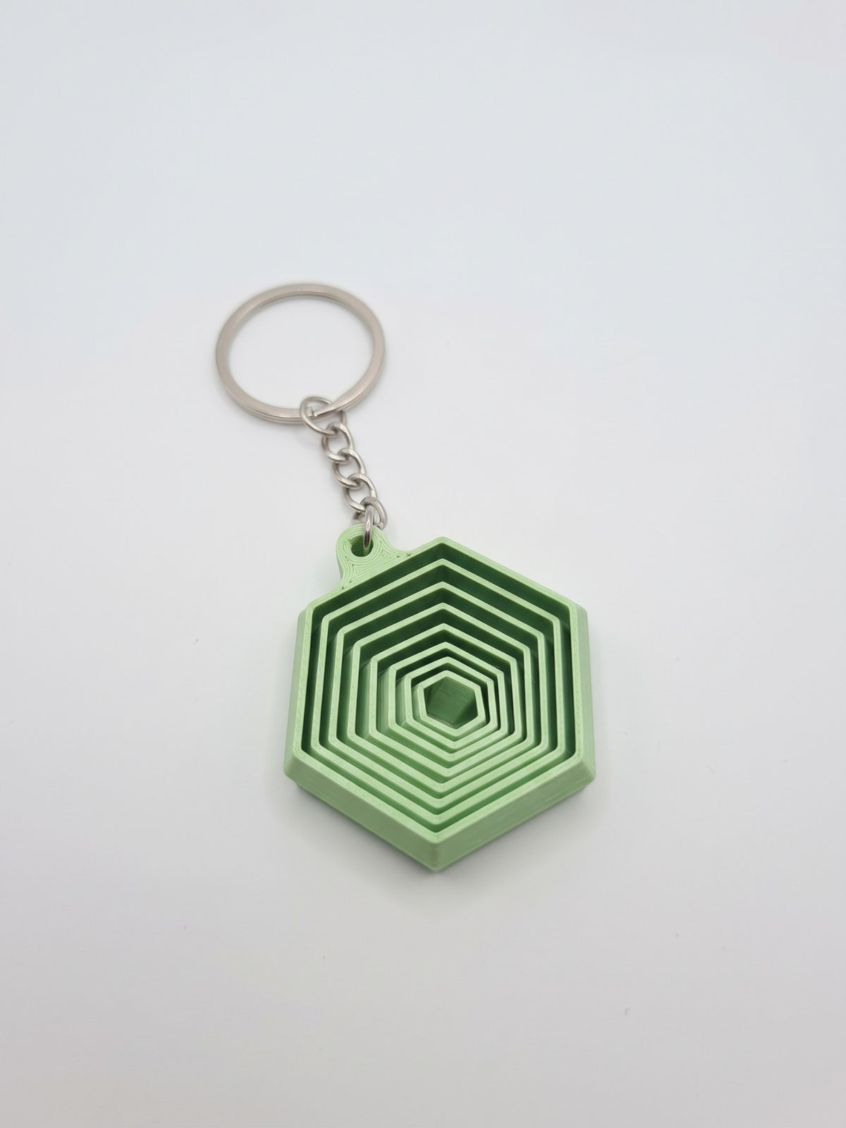 Llavero hexágono 3D verde pastel de capas encajadas